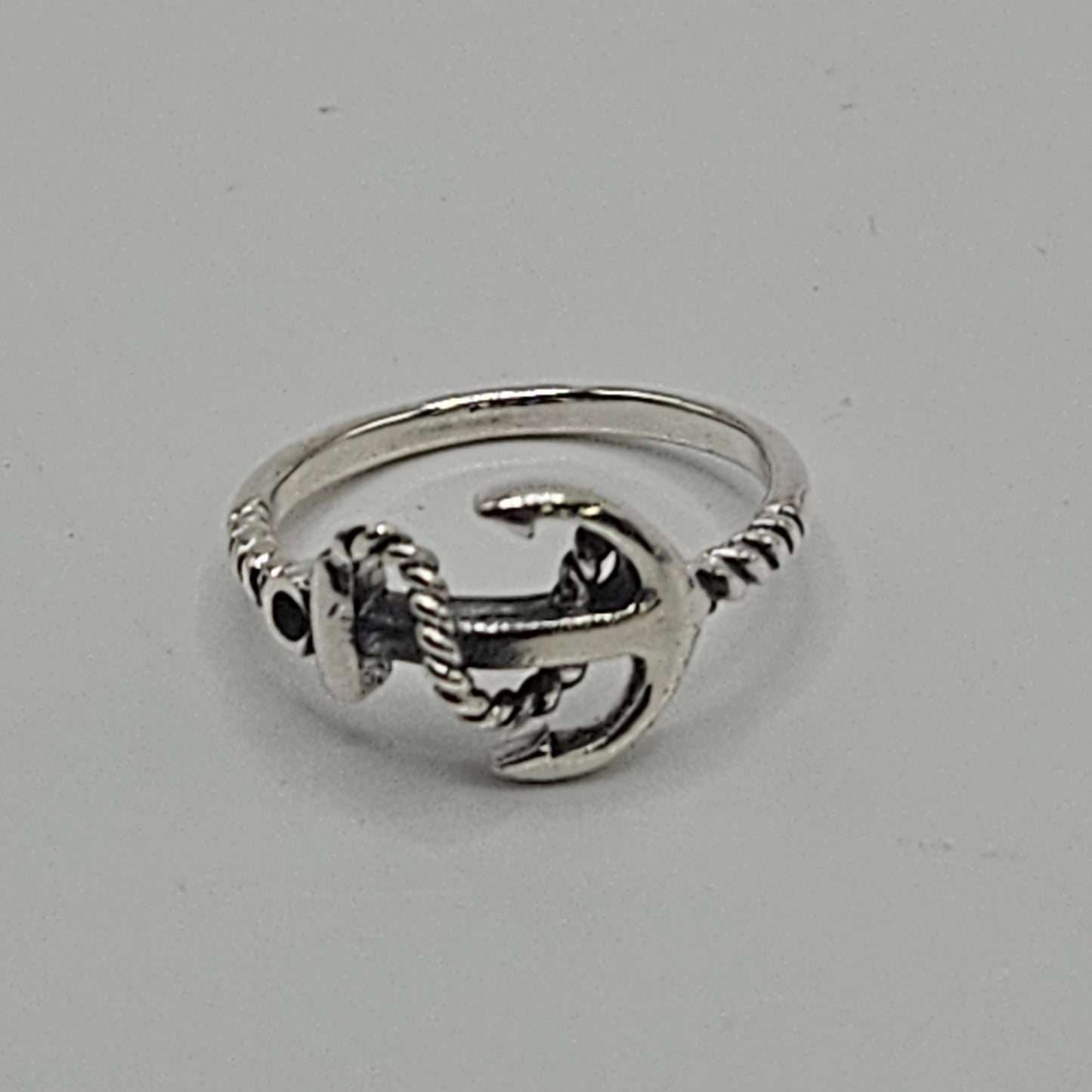 A silver-colored ring featuring an anchor motif