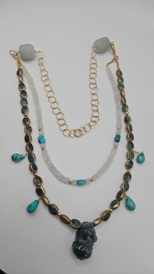 A multi-strand turquoise, moonstone, and jade dragon necklace with gold accents.