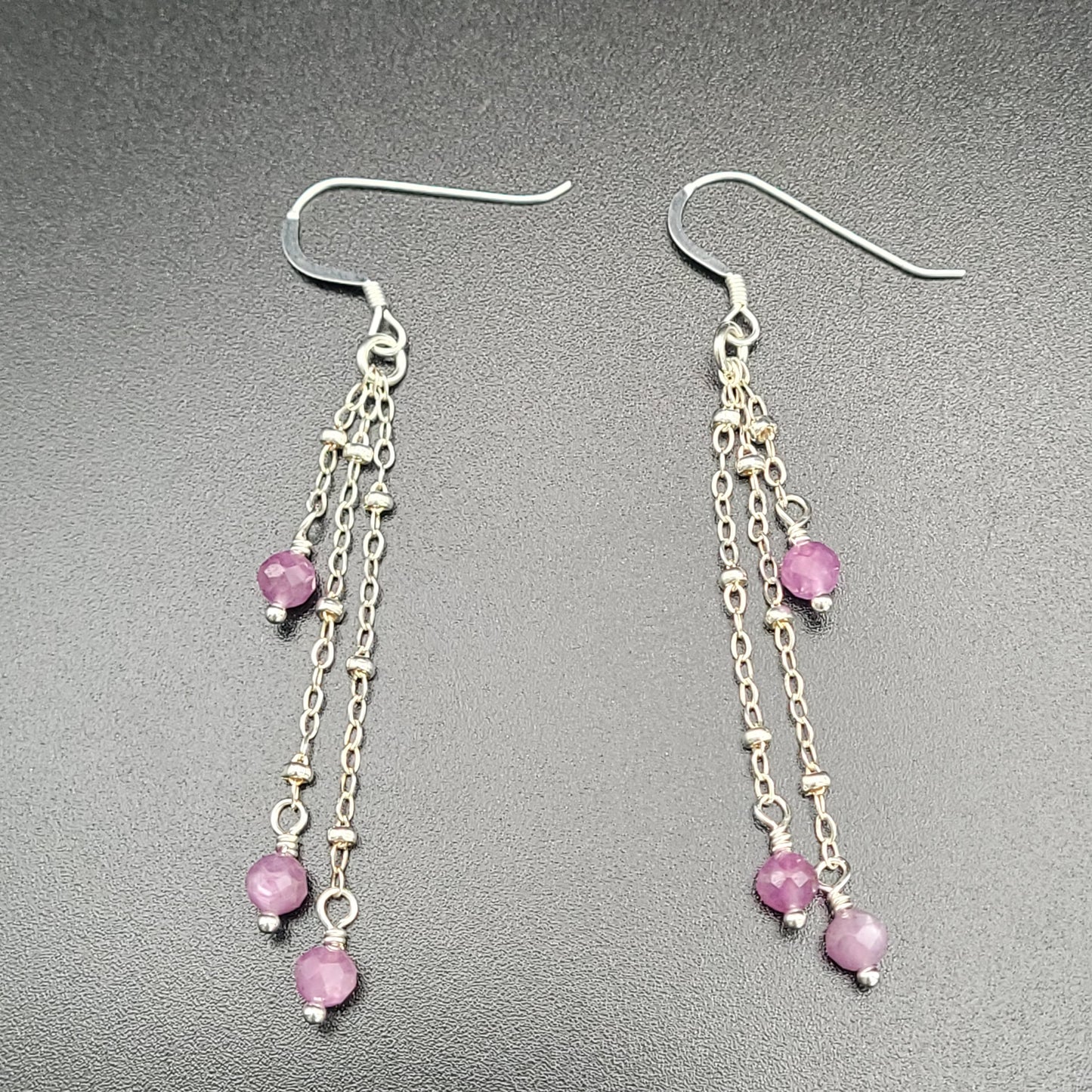 A pair of sterling silver ruby earrings with a vintage design, featuring intricate chain details and pink gemstone accents
