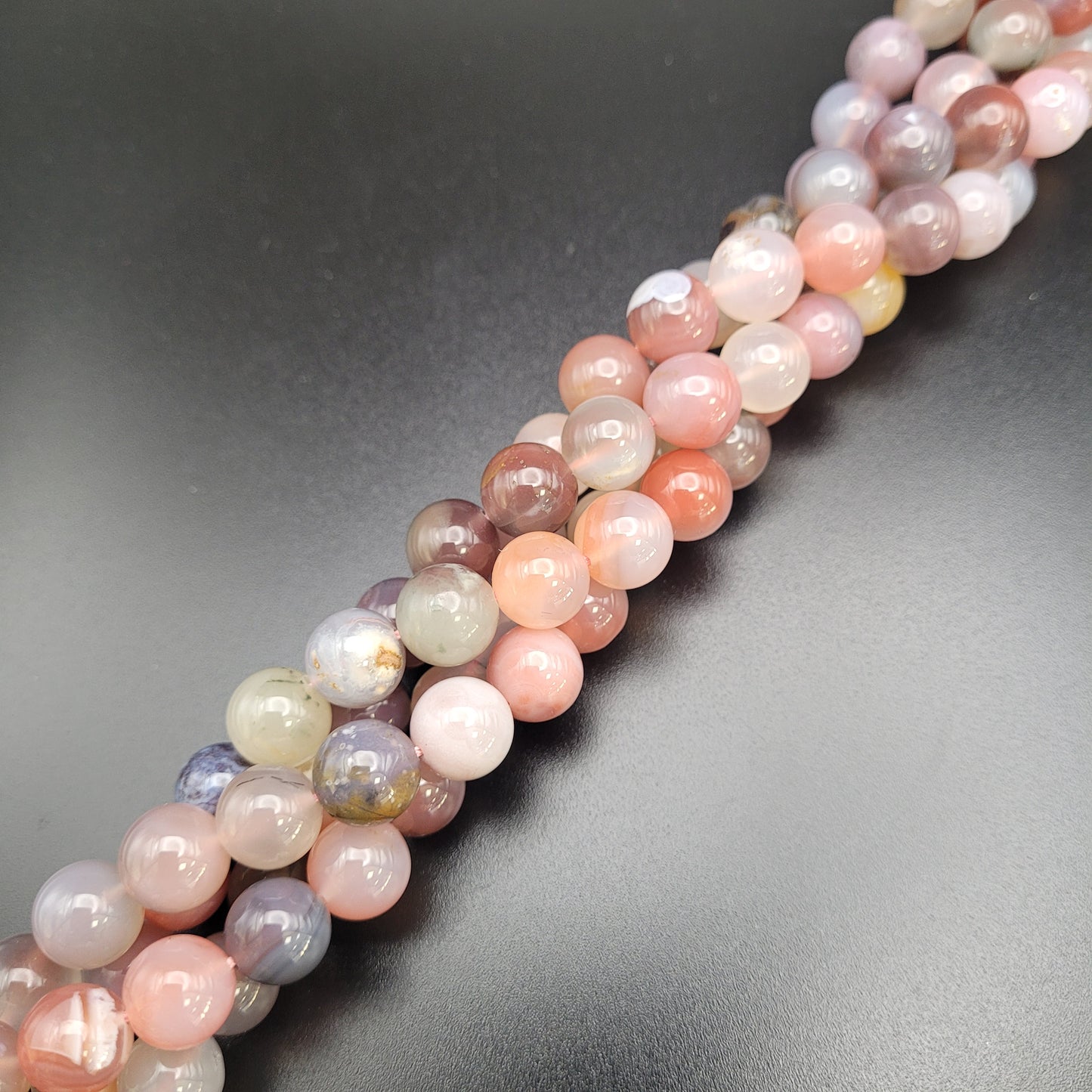 A strand of multicolored desert agate beads laid out on
