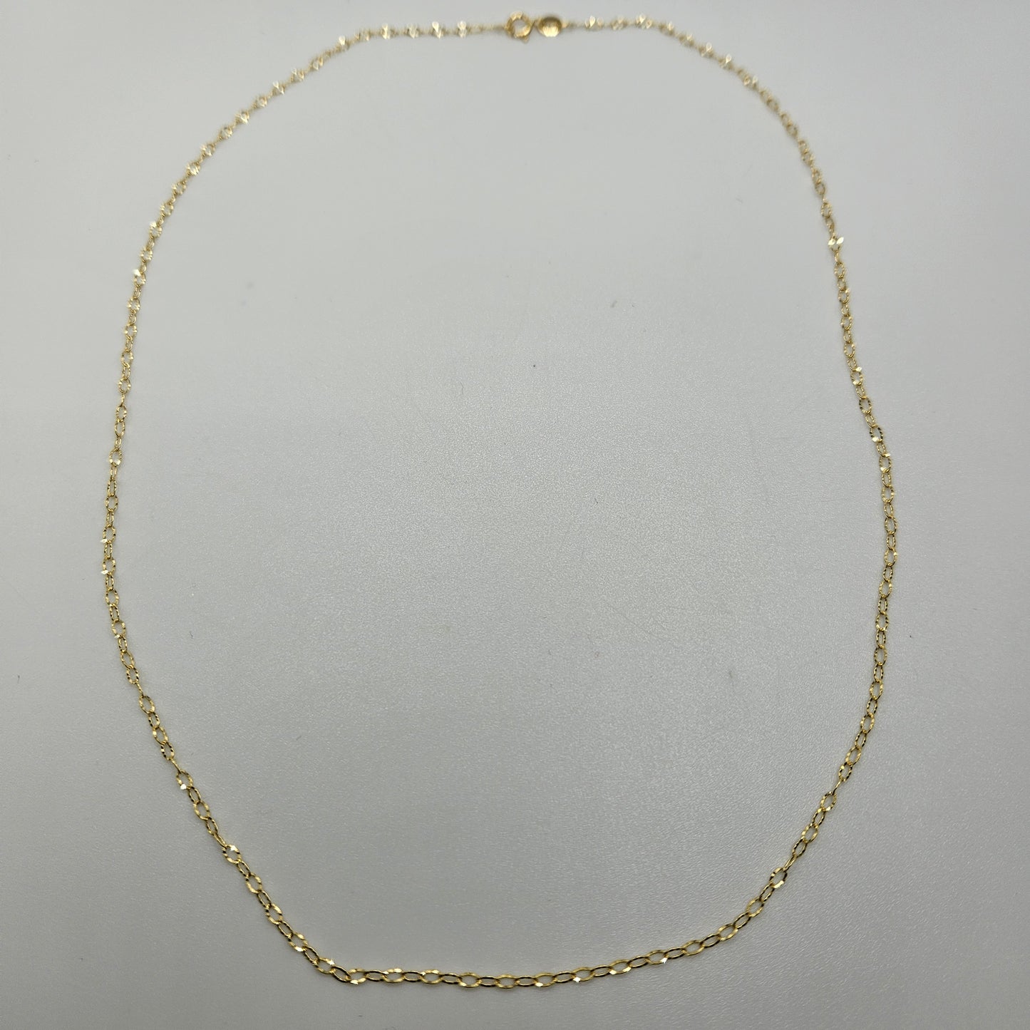 The 18" Diamond Cut Gold Cable Chain, with its delicate and evenly spaced links, is displayed on a plain white background.