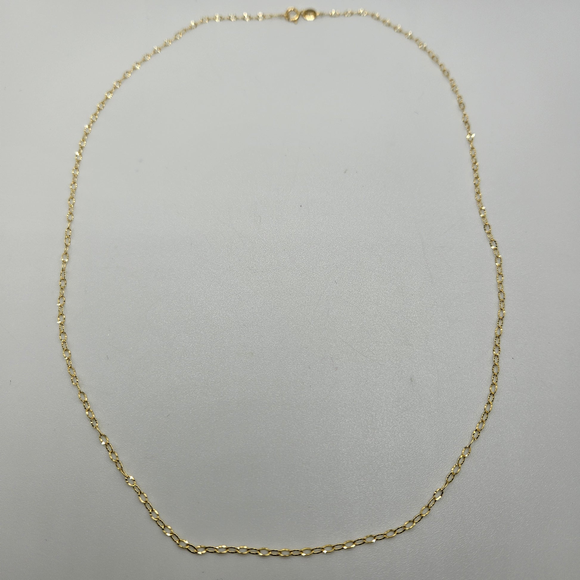 The 18" Diamond Cut Gold Cable Chain, with its delicate and evenly spaced links, is displayed on a plain white background.
