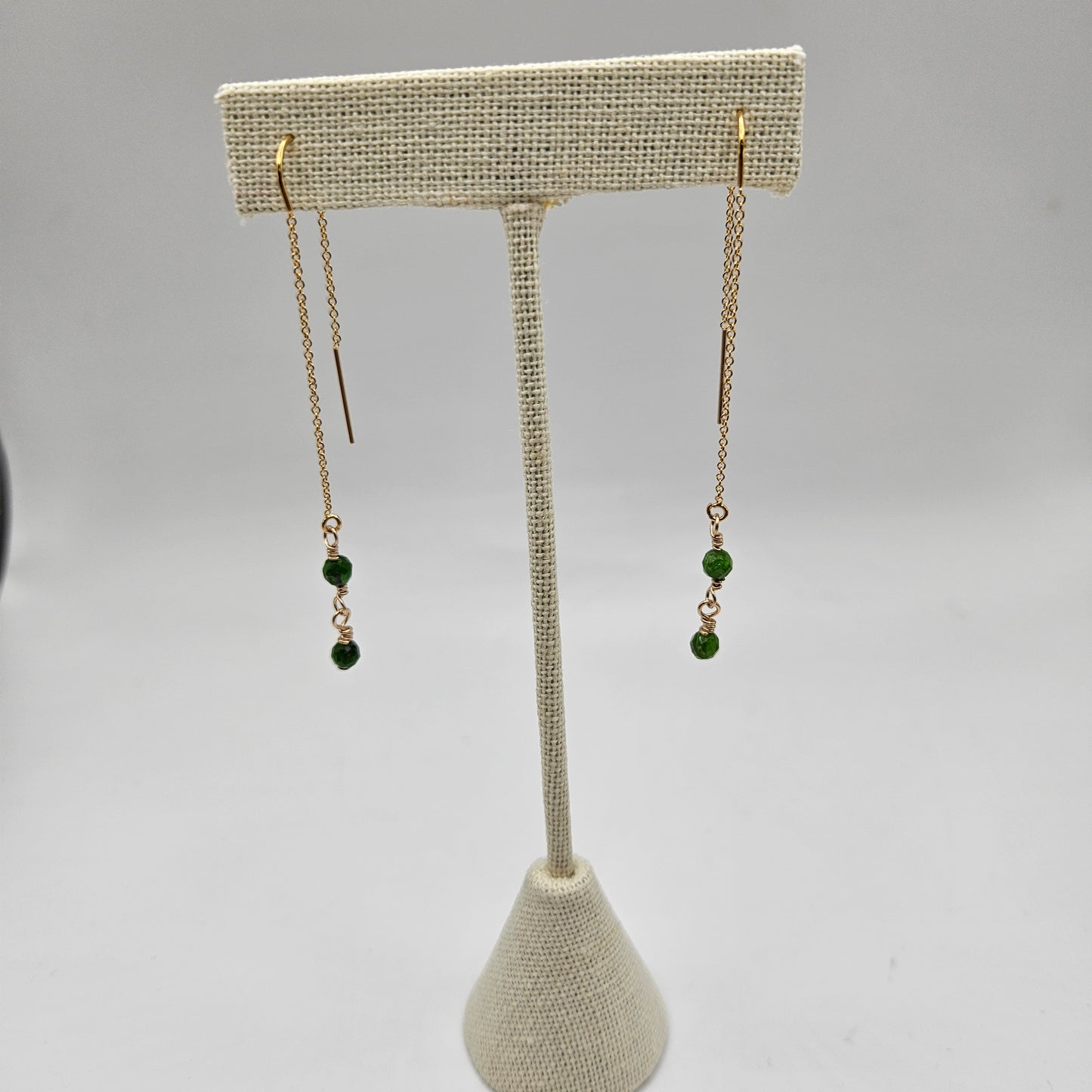 Gold-filled earrings with a geometric pattern, featuring a central diopside stone and smaller clear crystals,