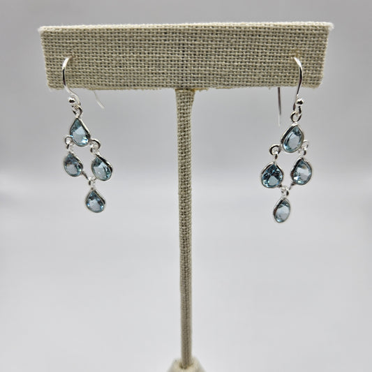 A pair of sterling silver teardrop faceted earrings with blue topaz stones.