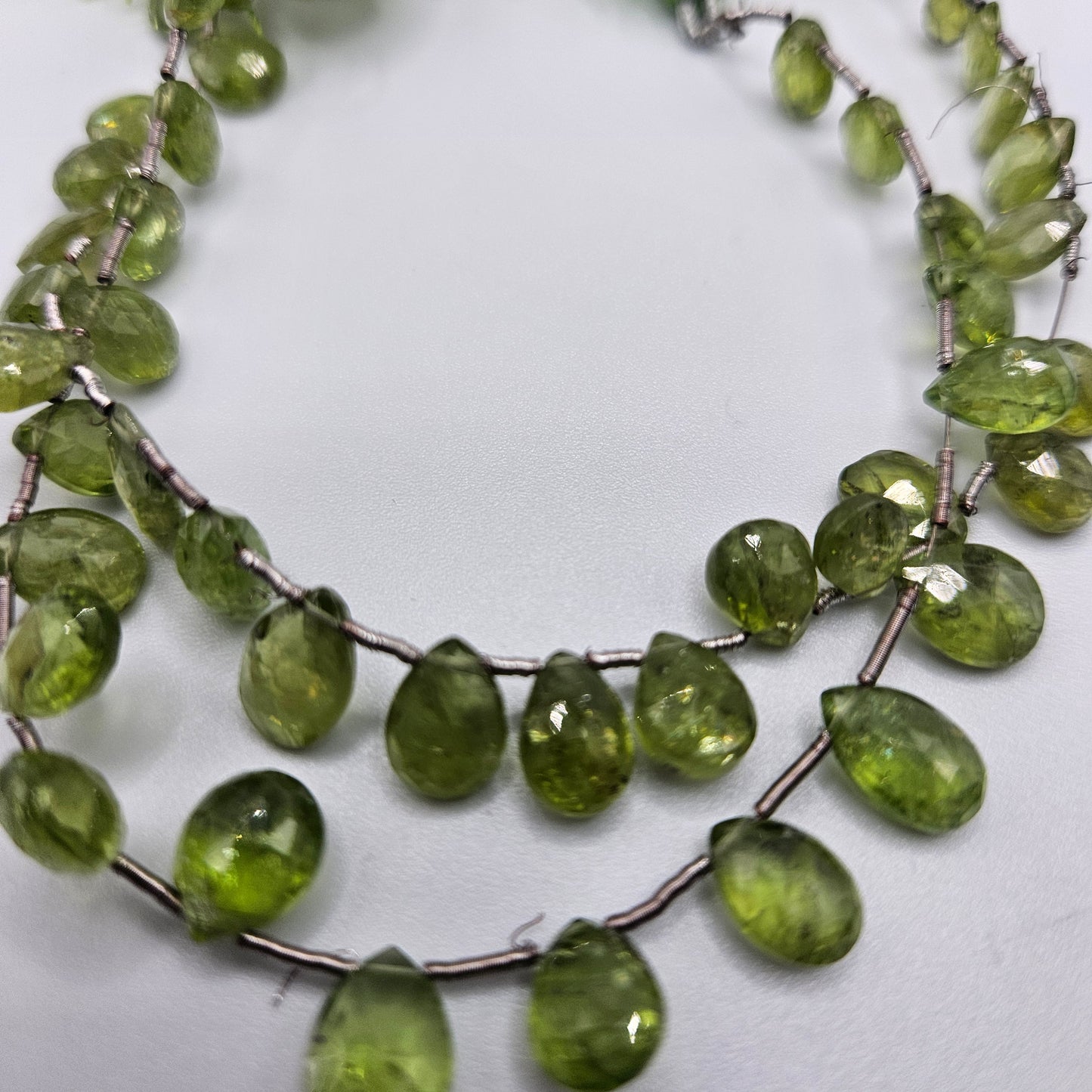 4 by 6mm faceted peridot top drill bead strand.