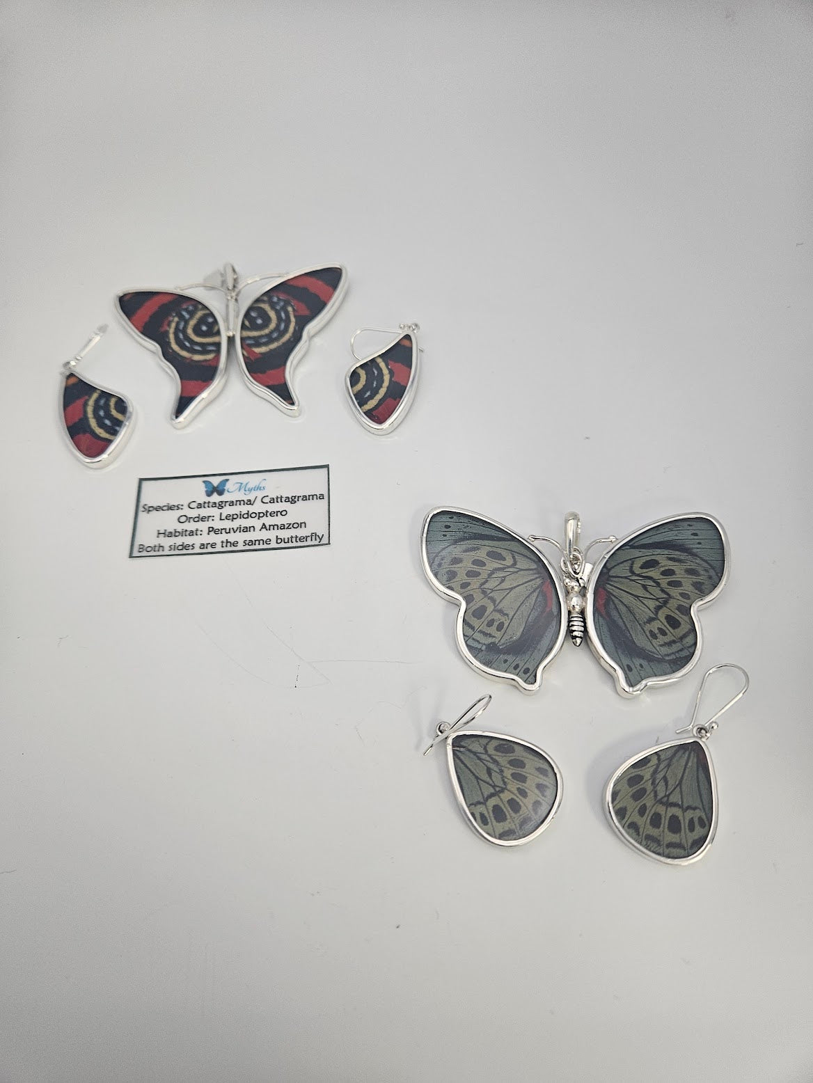Introducing the Sterling Silver Butterfly Wing Large Set, showcasing a striking red and black upper design paired with a subtle gray-green lower motif, inspired by Amazonian butterfly species. Similar to treasures found in a butterfly sanctuary, this set includes a card that describes both the artistry behind the design and the natural habitats of these butterflies.