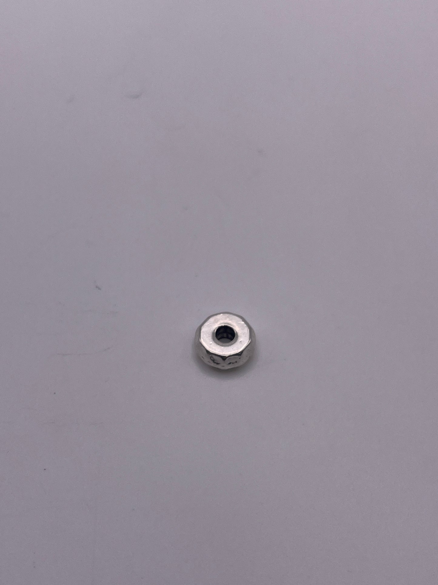 A Pewter Nut Single Bead .45 rests on a smooth, light gray surface.