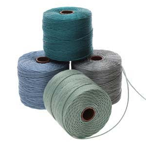 Four spools of S-Lon 210 Nylon Cord, each 77 yards long, are stacked in a pyramid formation. The cords are teal, blue, light green, and gray. One spool is on top while the other three are arranged underneath it. One strand of cord is slightly unraveled.
