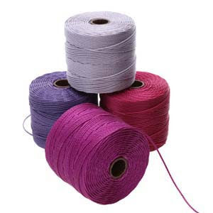 Four spools of S-Lon 210 Nylon Cord 77yd are stacked together, featuring colors in light gray, purple, red, and magenta. One spool sits on top while the other three form the base. A piece of the magenta nylon cord is slightly unwound.