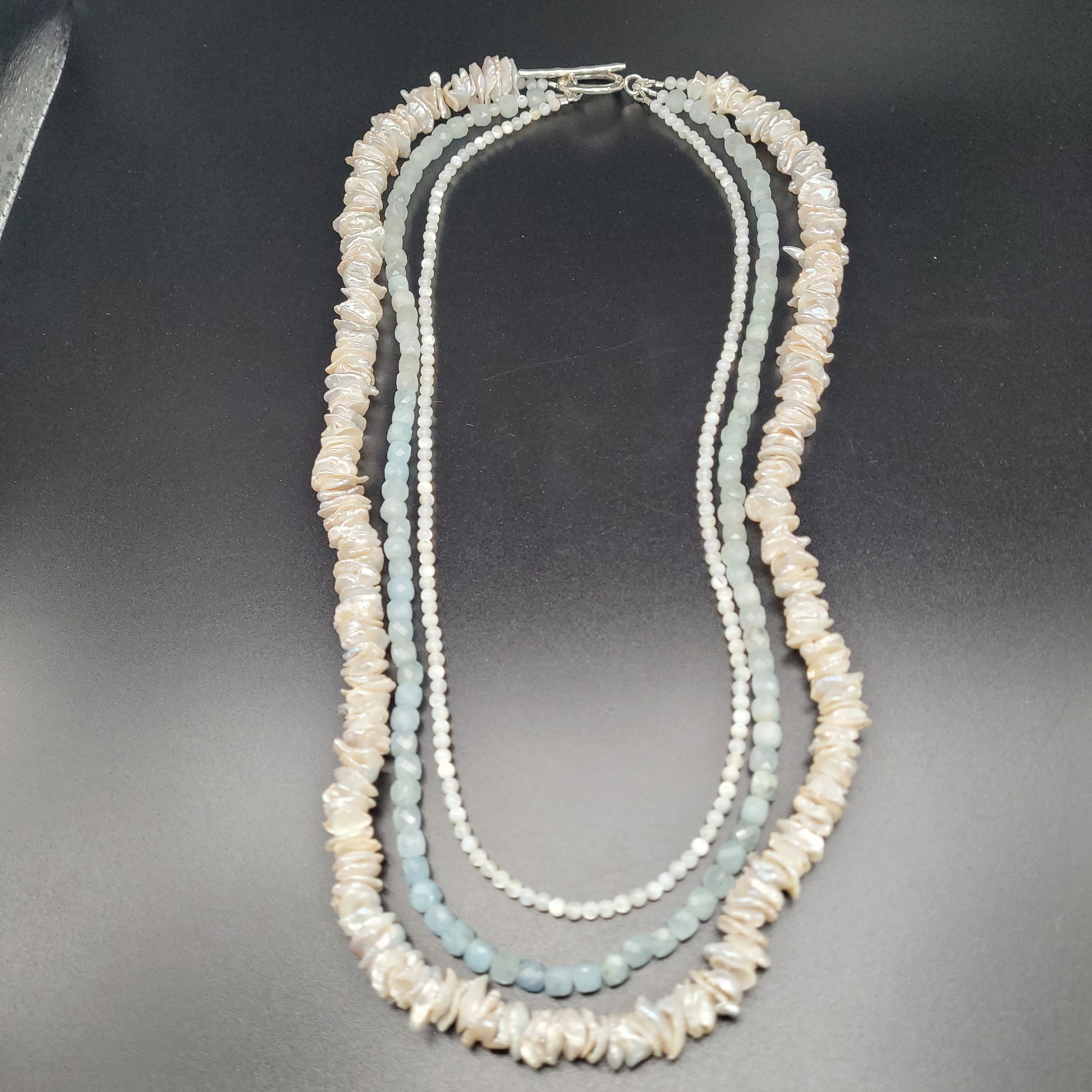 A sterling silver necklace with pearl and mother of pearl beads,