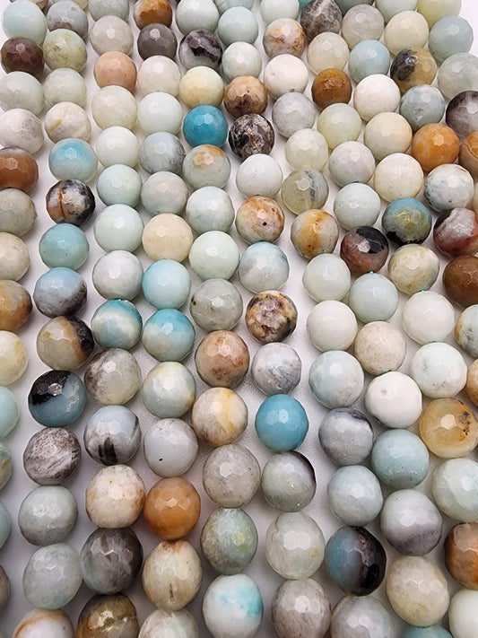 A close-up image of numerous 8mm Amazonite Faceted spherical beads arranged in rows. The beads display a variety of colors, including shades of blue, green, brown, white, and beige, with some exhibiting a marbled or mottled pattern.