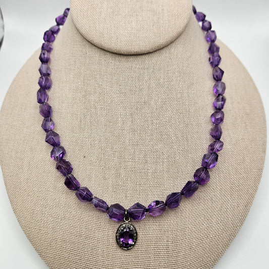 A purple amethyst crystal necklace with a diamond-shaped pendant 