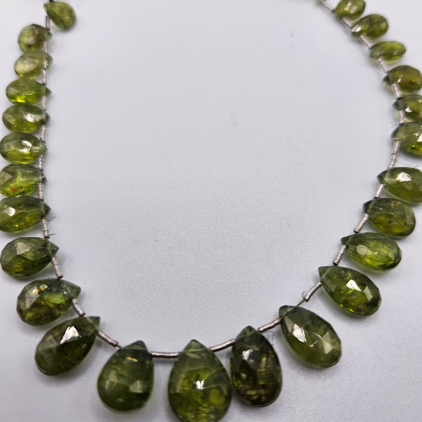5 by 8mm faceted graduated peridot top drill bead strand.