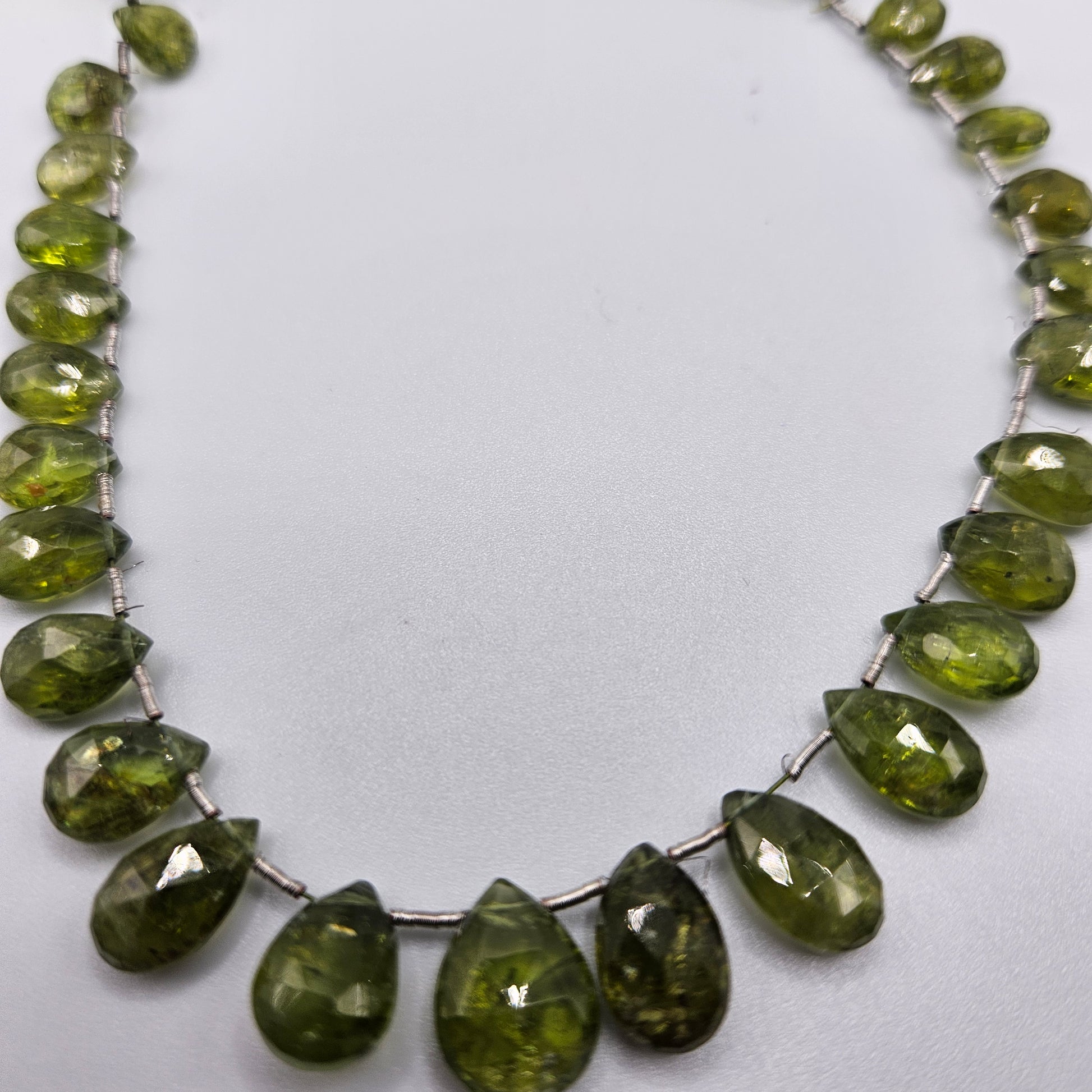 5 by 8mm faceted graduated peridot top drill bead strand.