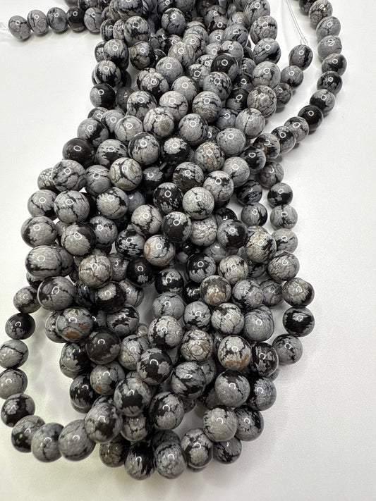 String of dark gray beads on a white background. 6mm Snowflake Obsidian Round Beads.