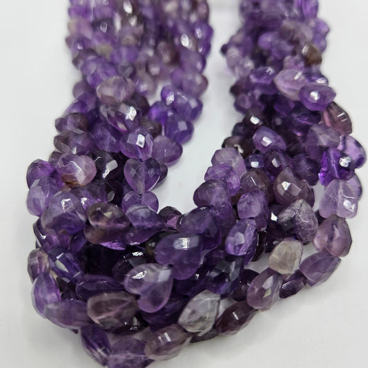 Close-up view of the 8mm Amethyst Faceted Heart Bead Strand, showcasing each bead's vibrant purple hues. The closely packed, faceted heart shapes create a rich and textured appearance.