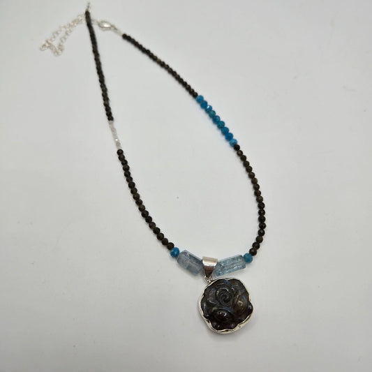A black and blue apatite necklace with silver accents and a chain.