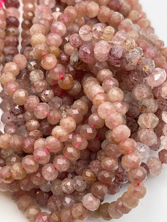 A close-up view of multiple strands of 6mm Fac Strawberry Quartz Rondell beads, intricately cut and polished to reflect light, creating a shimmering effect. The beads vary slightly in color intensity and are strung closely together.