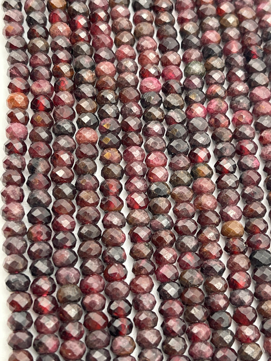 Rows of 5mm Fac Garnet Rondell beads in various deep shades of red, maroon, and brown are strung closely together. The beads have a glossy finish, reflecting light and creating a shimmering effect.